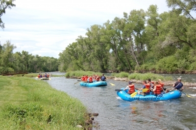 Group of rafts going down the Gunnison River at Camp Gunnison—The Way Household Ranch