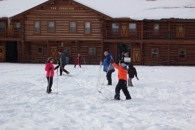 People playing on skis in the snow at Camp Gunnison—The Way Household Ranch