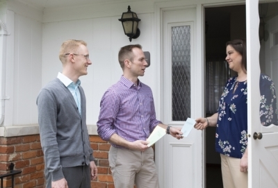 Two people witnessing to someone outside their house