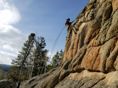 Person rappelling down a rock face