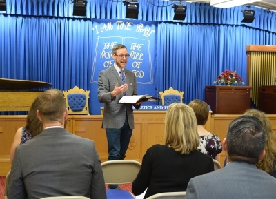 Person standing in front of an audience and teaching the Bible